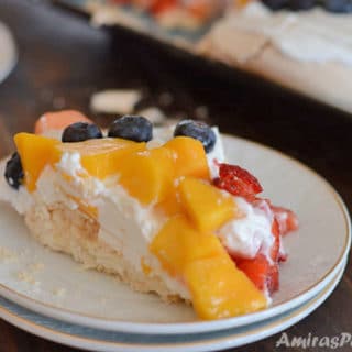 A piece of cake on a plate with fruits