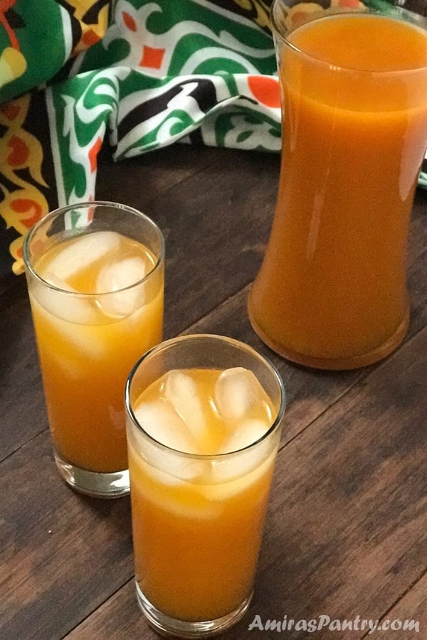 Three glasses with apricot juice on a wooden table
