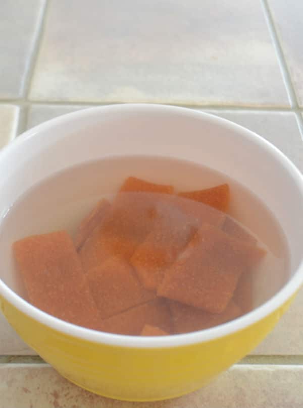 A close up of a bowl of dried apricot in water