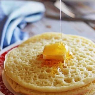  Une pile de crêpes marocaines avec un carré de beurre sur le dessus et un filet de miel.