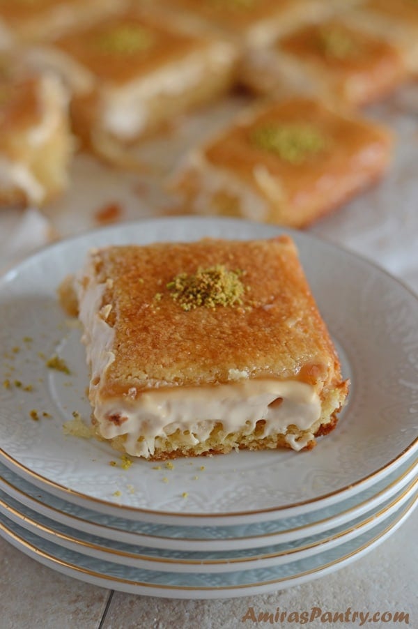 A piece of cake on a plate with Basbousa and cream