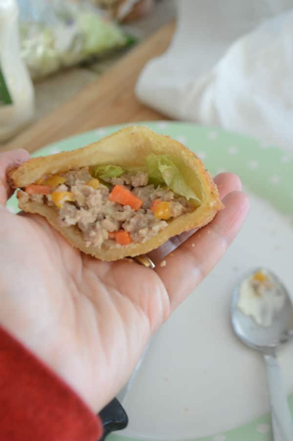 A hand holding an open sandwich with stuffing