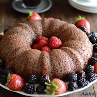 A plate of food on a table, with powdered Cake and berries