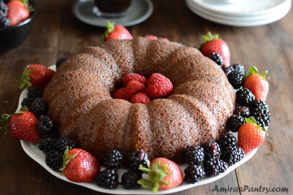 A plate of food on a table, with powdered Cake and berries