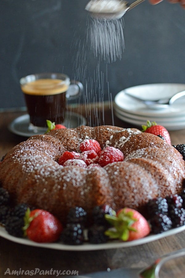 A plate of food on a table, with powdered Cake and berries