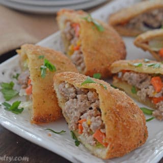 A plate of food, with Sandwich stuffed with meat