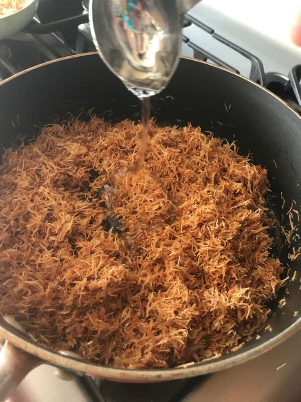 A bowl of food on a stove with knafeh