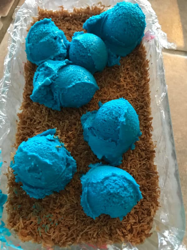 A mixture of knafeh and blue icecream in a glass pan