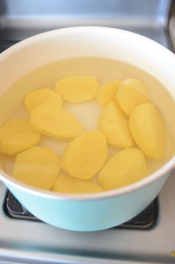 boiling potato in water to make cheesy chicken mashed potato caseerole.