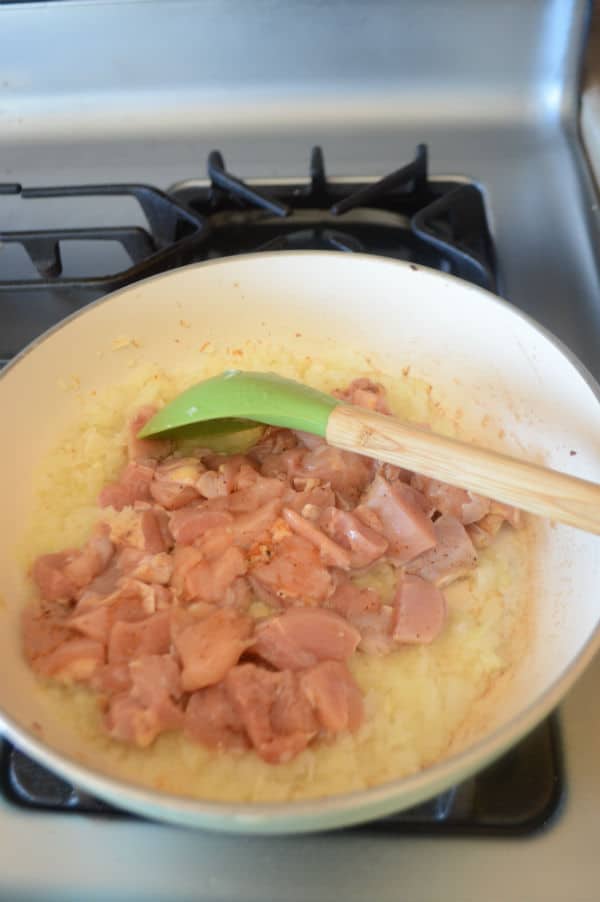 sauting onion and chicken in a skillet to make filling for the potato balls.