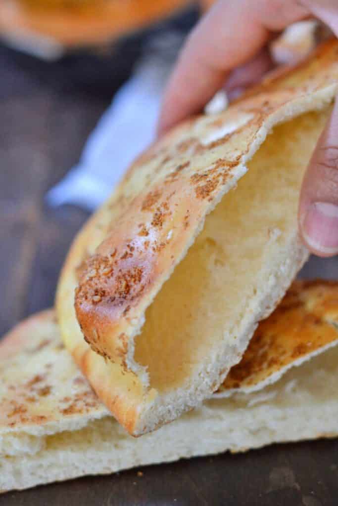 A hand holding a khameer pita pocket.