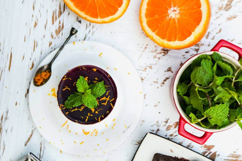 A photo of oranges on a table, with Mint and Mousse dessert on a plate