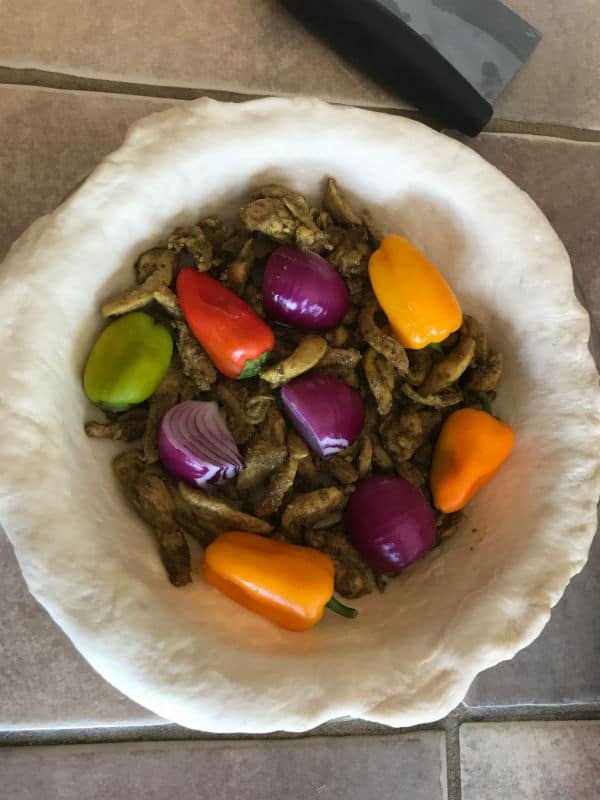 A bowl of food, with Shawarma and vegetables before baking