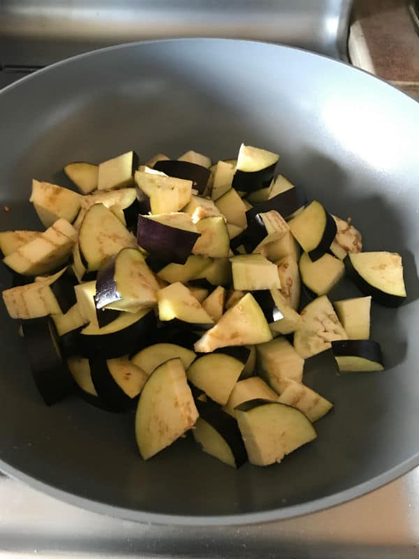 A pan of food with raw eggplant