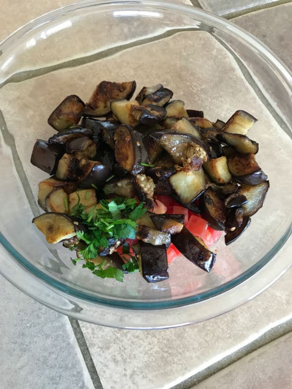 A plate of food, with eggplant and vegetables