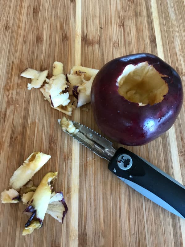 A cut apple sitting on top of a wooden cutting board