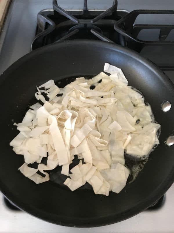 A pan of food on a stove, with pastry