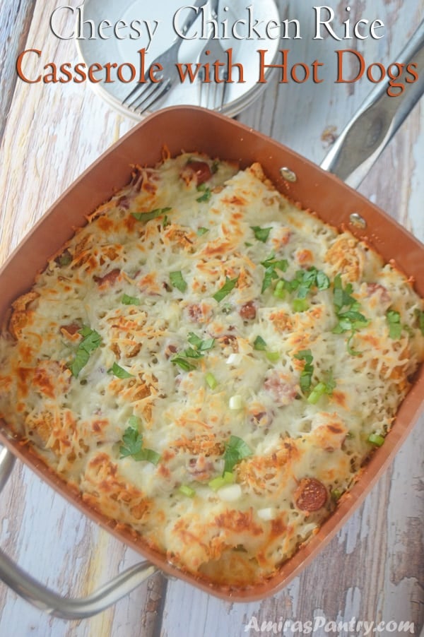 A pot with rice and cheese and chicken on wooden table