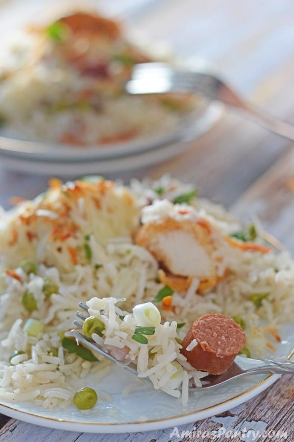 A plate of food with rice and vegetables, with Chicken, meat vegetables