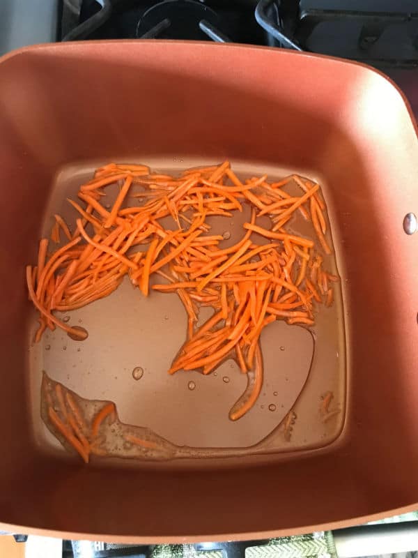 A close up of a pot with carrots