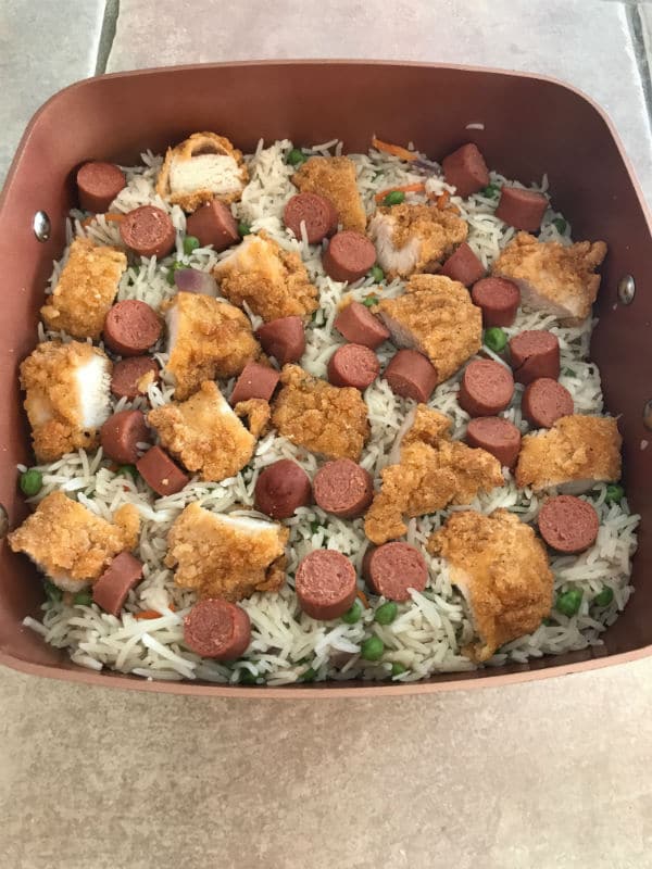 A close up for a pot with vegetables, rice and meat