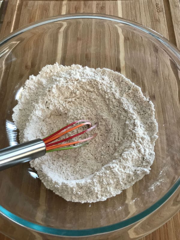 A mixture in a glass bowl over wooden table