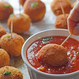 A plate of food on a table, with Pizza balls and dip
