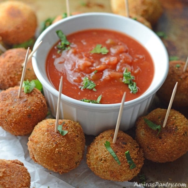 A plate of food on a table, with Pizza balls and dip