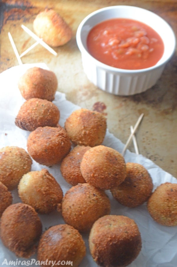 A plate of food on a table, with Pizza balls and dip