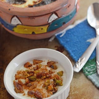 A bowl of food on a plate, and Rice Pudding on a spoon