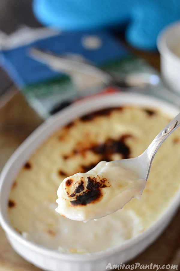 A bowl of food on a plate, and Rice Pudding on a spoon