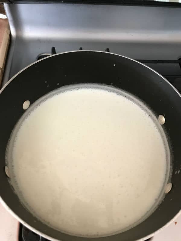 A close up of a pan on a stove, with Rice pudding
