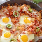 A dish is filled with food, with Egg, cheese and Potato