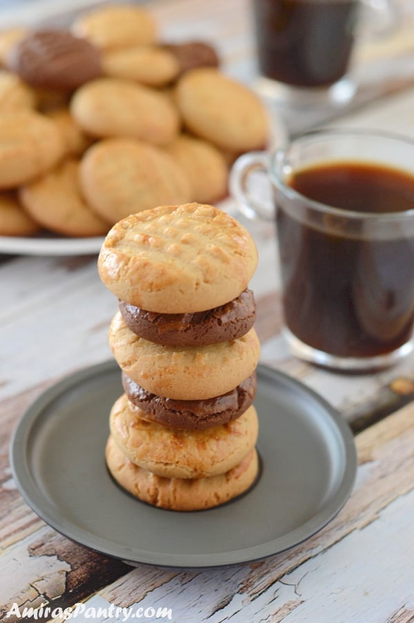 A close up of cookies on a plate nd a cup of coffee