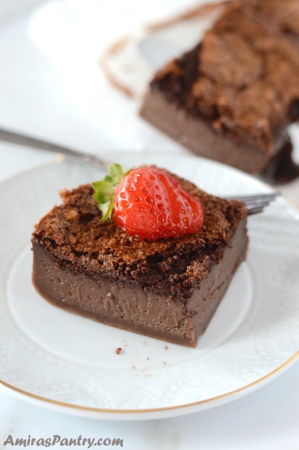 A piece of chocolate cake on a plate with strawberry