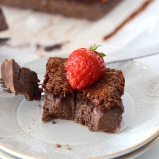 A piece of chocolate cake on a plate with strawberry
