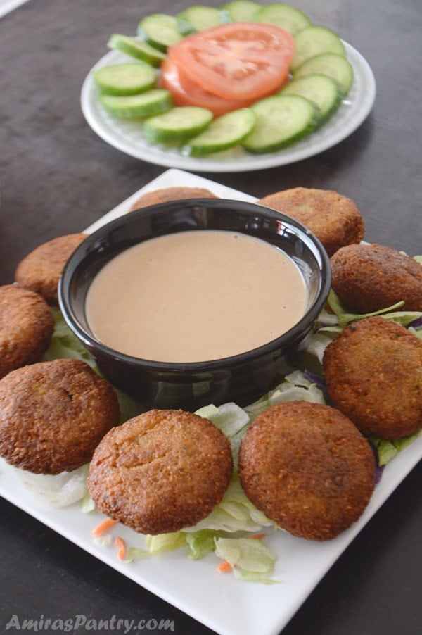 A plate of food on a table, with Falafel and dip