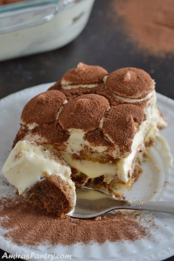 A close up of a plate with a piece of Tiramisu