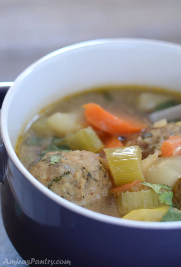 A serving bowl with turkey albondigas soup in it.