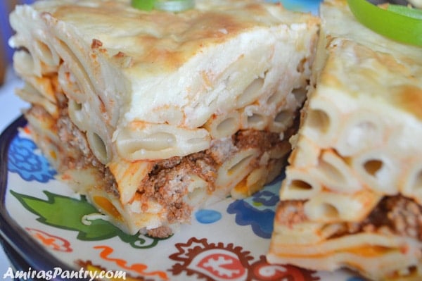 close up photo showing layers of pasta, ground meat and topping all that with bechamel sauce.