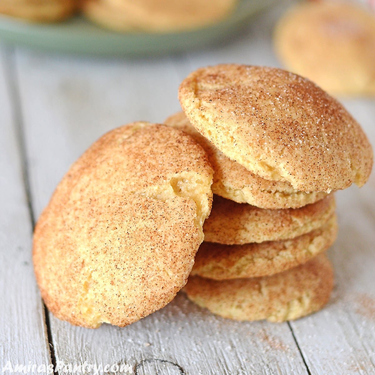 snickerdoodle cookies on a wooden table with one cookie tilted on the side