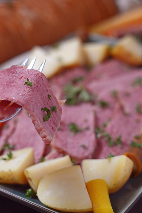 A fork holding a slice of the tender corned beef.