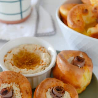 A photo showing yorkshire puddings on a plate with dip