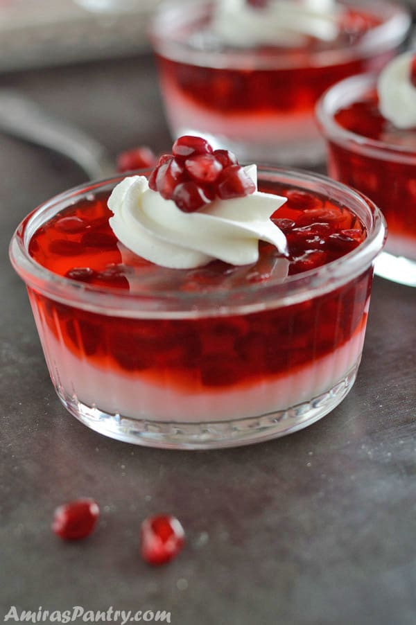 A glass cup on a table filled with pomegranate parfaits