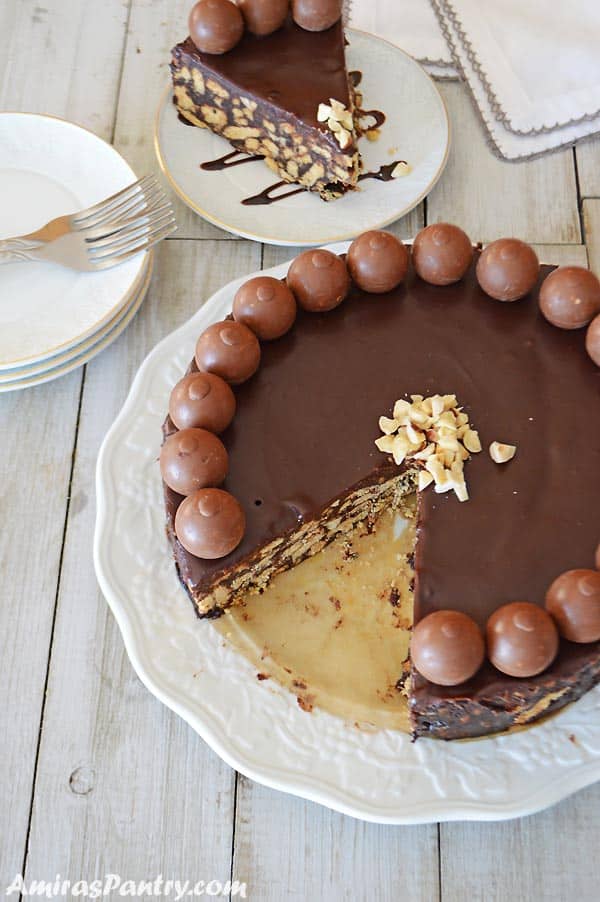 A big white plate with the Chocolate Biscuit Cake over and a slice is cut out and placed on a white plate on the side.