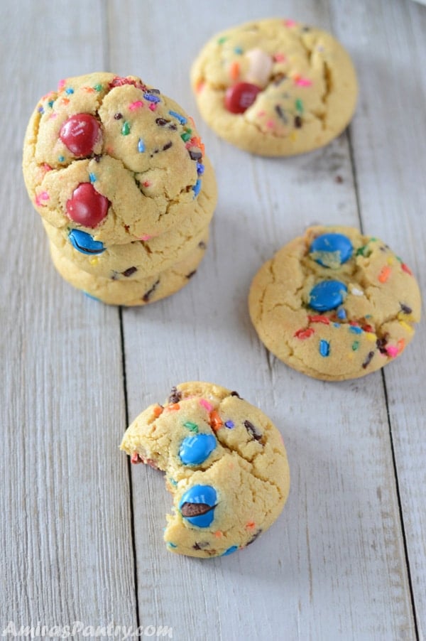 A stack of fireworks pudding cookies with some on the table and one being bitten off.