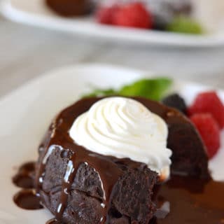 A close up of a piece of chocolate cake on a plate, with Cream