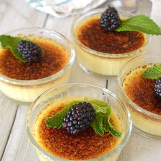 A close up of creme brulee in cups with berries