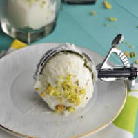A scoop of Lebanese booza ice cream on a white plate sprinkled with pistachios
