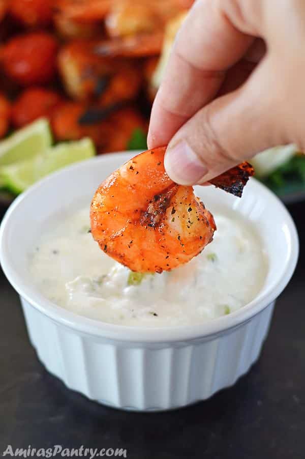 Hand dipping grilled shrimp with the best marinade ever in a whole yogurt sauce.